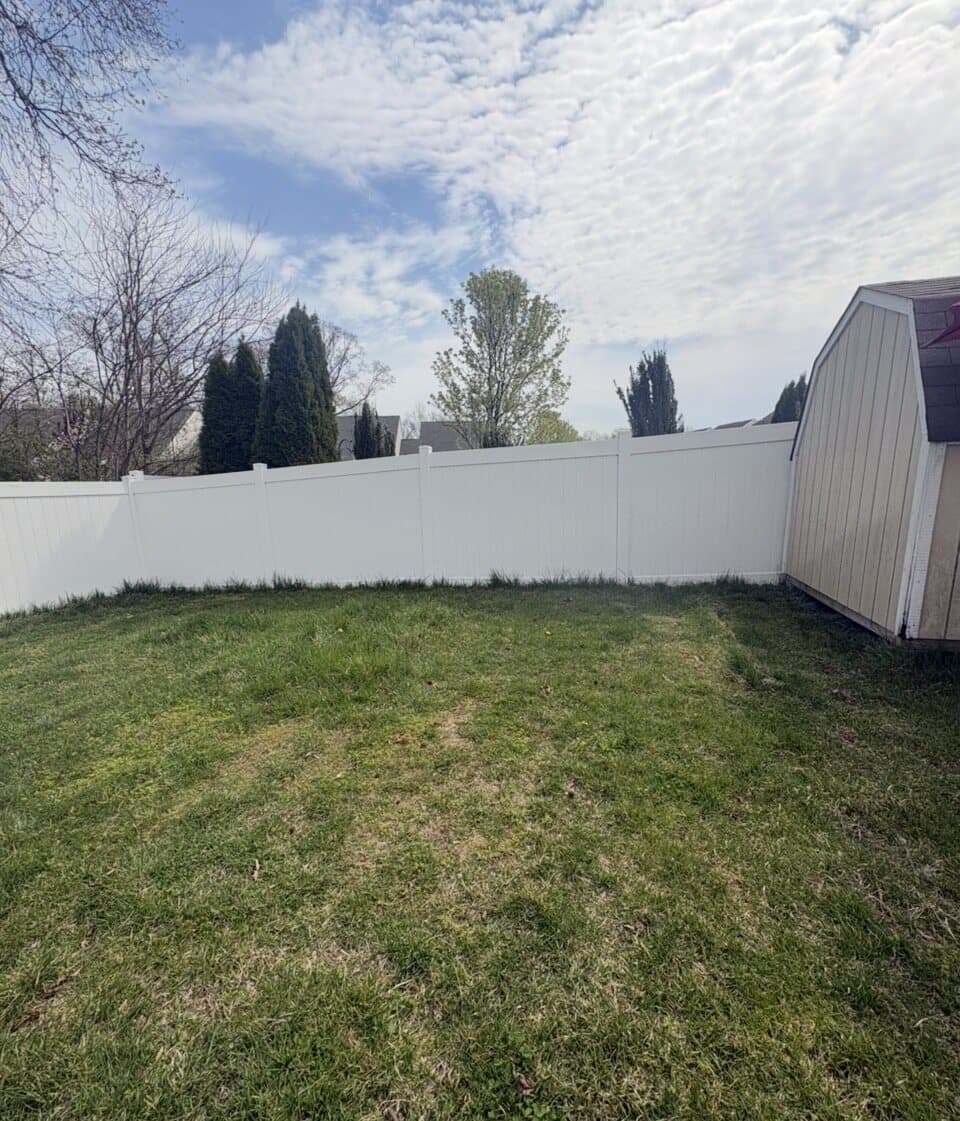 White privacy fence installed around a backyard